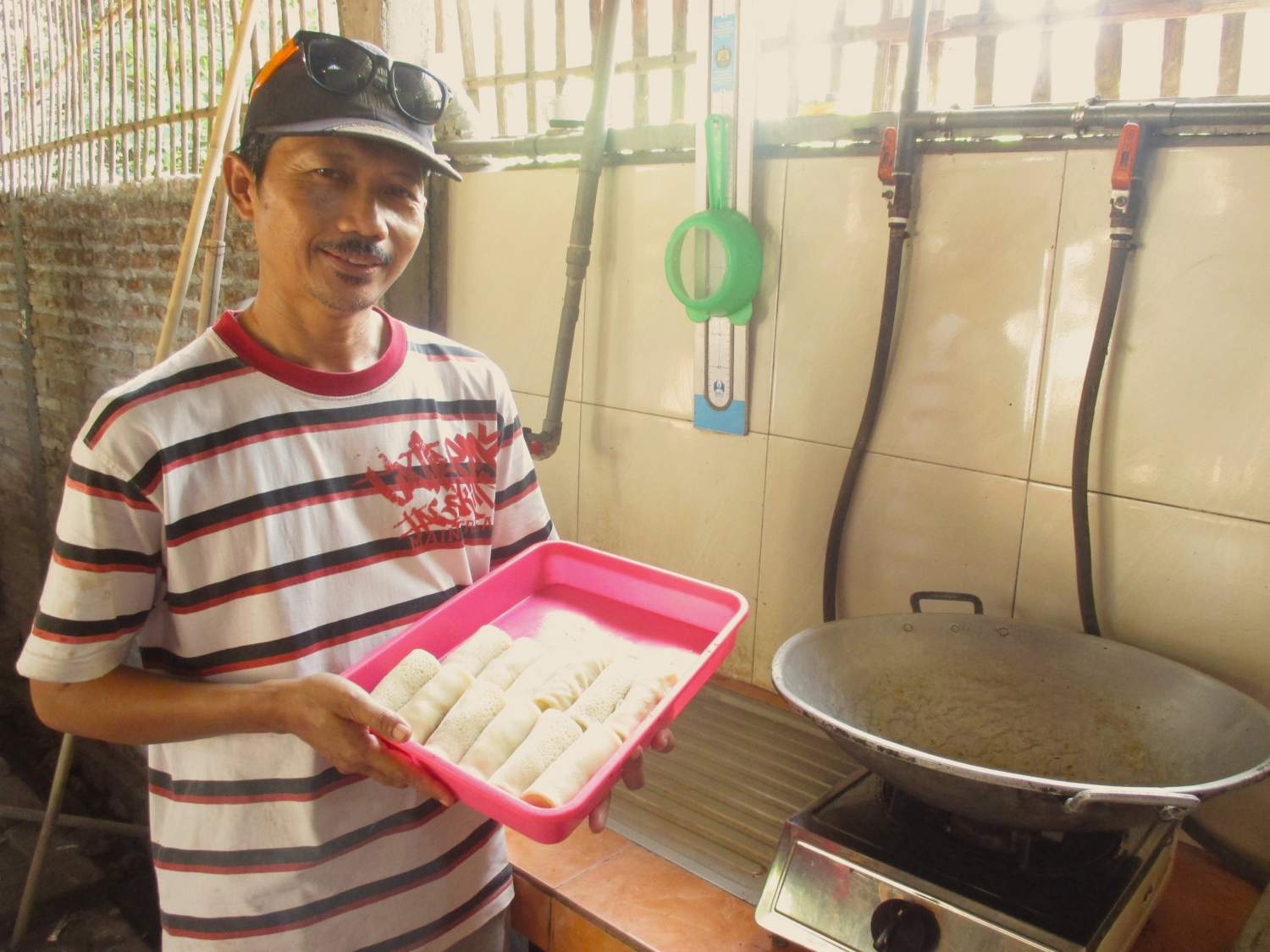 Pak Arum showing off his rissoles, cooked using biogas (Credit: Christina Haryanto Putri)