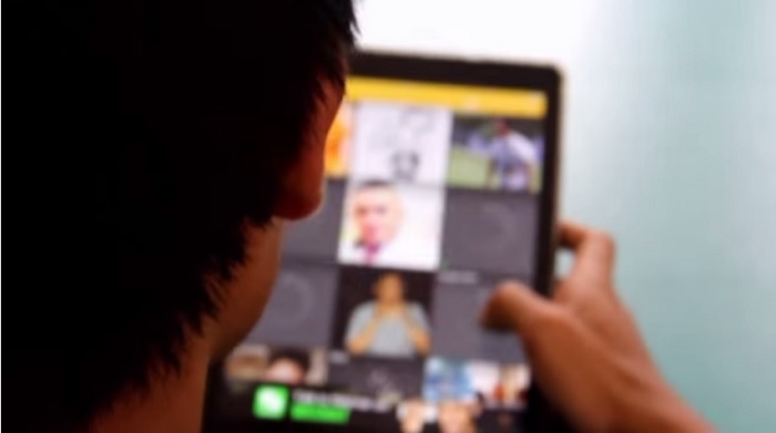 Screenshot: A young man looks over the Grindr app interface. (Brondongmanis Channel via Youtube)